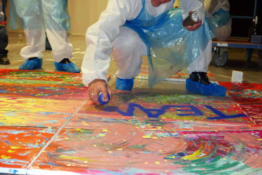 Gemeinsames Firmenkunstwerk entsteht während eines kreativen Teamworkshops